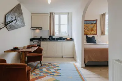 a kitchen and a bedroom with a bed and a table at Cozy Hideaway Near the Heart of Antwerp in Antwerp