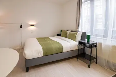 a bedroom with a bed with a table and a window at Cinquantenaire 1 in Brussels