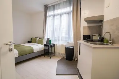 a small kitchen with a bed and a sink in a room at Cinquantenaire 1 in Brussels