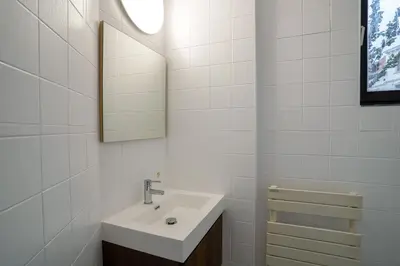 a white bathroom with a sink and a mirror at Cinquantenaire 1 in Brussels