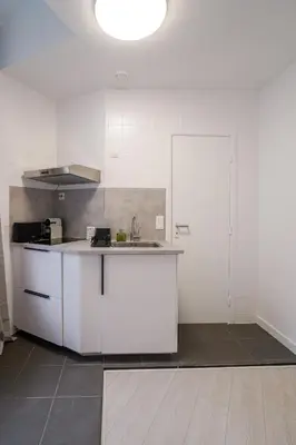 a kitchen with white cabinets and a sink at Cinquantenaire 1 in Brussels