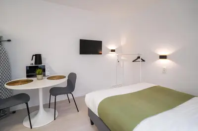 a hotel room with a bed and a table and a bed at Cinquantenaire 1 in Brussels