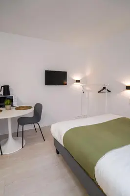 a bedroom with a bed and a table and a chair at Cinquantenaire 1 in Brussels