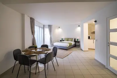 a living room with a table and chairs and a bed at Schuman 2 in Brussels