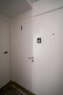 a white wall with a door with a clock on it at Schuman 2 in Brussels