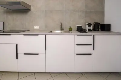 a kitchen with white cabinets and a sink at Schuman 2 in Brussels