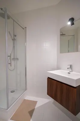 a white bathroom with a sink and a shower at Schuman 2 in Brussels