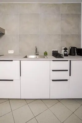 a kitchen with white cabinets and a sink at Schuman 2 in Brussels