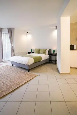 a bedroom with a bed and a tiled floor at Schuman 2 in Brussels