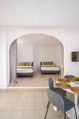 a living room with two beds and tables and chairs at Schuman 2 in Brussels