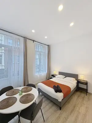 a bedroom with a bed and two tables and chairs at Fernand Cocq in Brussels