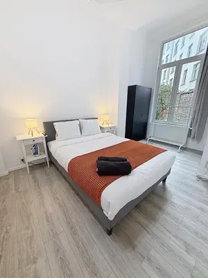 a bedroom with a bed and a large window at Fernand Cocq in Brussels