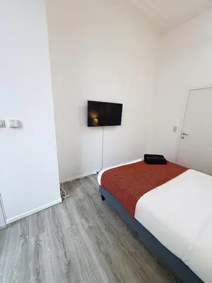 a bedroom with a bed and a flat screen tv at Fernand Cocq in Brussels