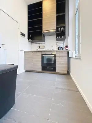 a kitchen with wooden cabinets and a tile floor at Fernand Cocq in Brussels
