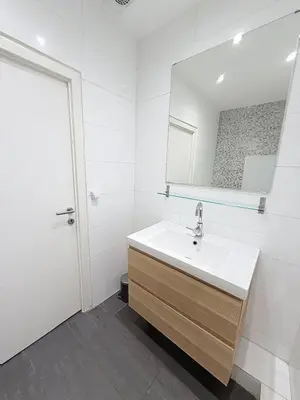 a white bathroom with a sink and a mirror at Fernand Cocq in Brussels