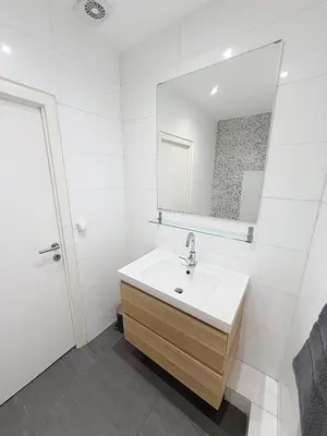 a white bathroom with a sink and a mirror at Fernand Cocq in Brussels