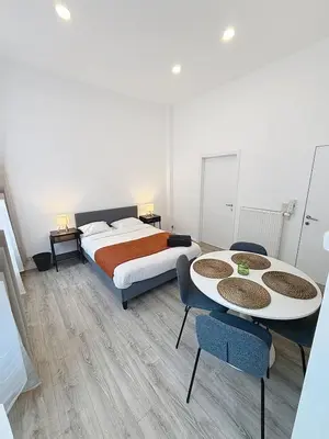 a bedroom with a bed and two tables and chairs at Fernand Cocq in Brussels