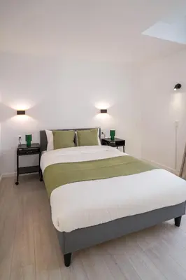 a bedroom with a large bed with two night stands at Mérode 3 in Brussels
