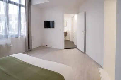 a bedroom with a bed and a television on a wall at Mérode 3 in Brussels