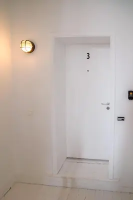 a white door with a light on the wall at Mérode 3 in Brussels