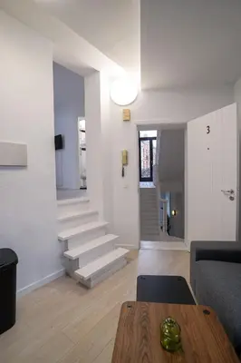 a living room with stairs and a couch and a table at Mérode 3 in Brussels