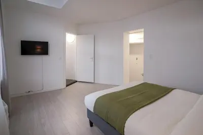 a bedroom with a bed and a tv on a wall at Mérode 3 in Brussels