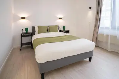 a bedroom with a large bed with two night stands at Mérode 3 in Brussels