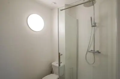 a white bathroom with a shower and a toilet at Jourdan 4 in Brussels