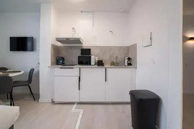 a kitchen with white cabinets and a counter with a microwave at Jourdan 4 in Brussels