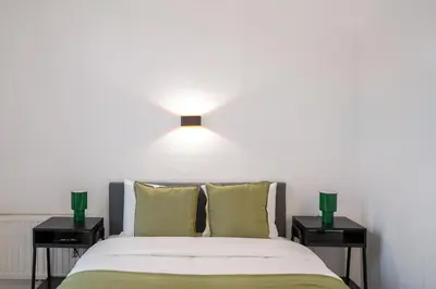 a bedroom with a bed with two nightstands and a light above it at Jourdan 4 in Brussels
