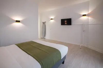 a bedroom with a bed and a tv on the wall at Jourdan 4 in Brussels