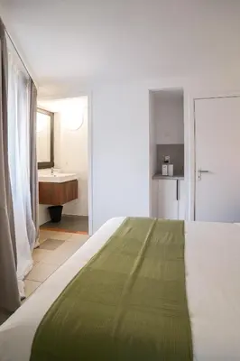 a bedroom with a bed and a bathroom with a sink at La Chasse 5 in Brussels