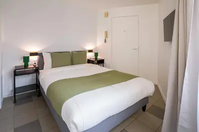 a bedroom with a large bed with two night stands at La Chasse 5 in Brussels