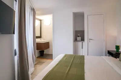 a bedroom with a bed and a bathroom with a sink at La Chasse 5 in Brussels