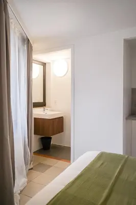 a bedroom with a bathroom with a sink and a bed at La Chasse 5 in Brussels