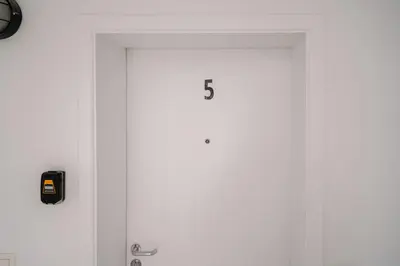 a white door with the number on it at La Chasse 5 in Brussels