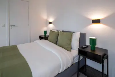 a bedroom with a bed and a nightstand with two lamps at Luxembourg 6 in Brussels