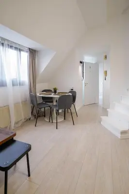 a living room with a table and chairs and stairs at Luxembourg 6 in Brussels