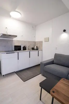 a living room with a couch and a kitchen at Luxembourg 6 in Brussels