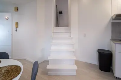 a white staircase in a room with a table at Luxembourg 6 in Brussels