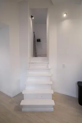 a white staircase in a room with white walls at Luxembourg 6 in Brussels