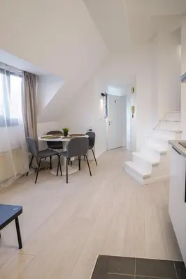 a living room with stairs and a table and chairs at Luxembourg 6 in Brussels