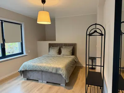 a bedroom with a bed and a large window at Appartement Brussels Expo II in Grimbergen