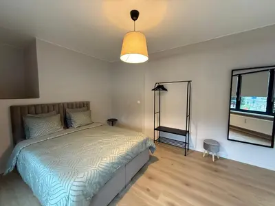 a bedroom with a bed and a lamp and a window at Appartement Brussels Expo II in Grimbergen