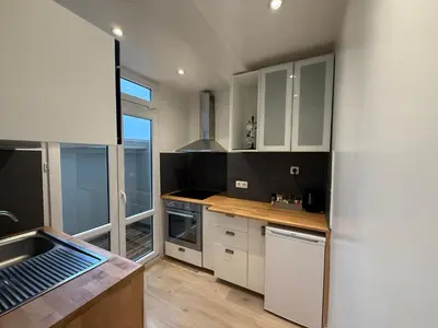 a kitchen with white cabinets and a large window at Appartement Brussels Expo II in Grimbergen