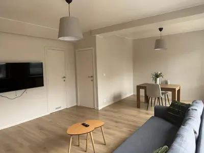 a living room with a blue couch and a table at Appartement Brussels Expo II in Grimbergen