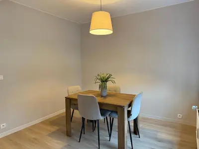 a dining room table with chairs and a light fixture at Appartement Brussels Expo II in Grimbergen