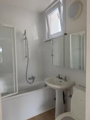 a white bathroom with a sink and a shower at Appartement Brussels Expo II in Grimbergen