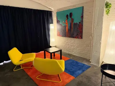 a living room with two yellow chairs and a table at Spacious BXL Loft in Brussels