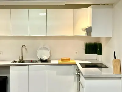 a white kitchen with white cabinets and a sink at Spacious BXL Loft in Brussels